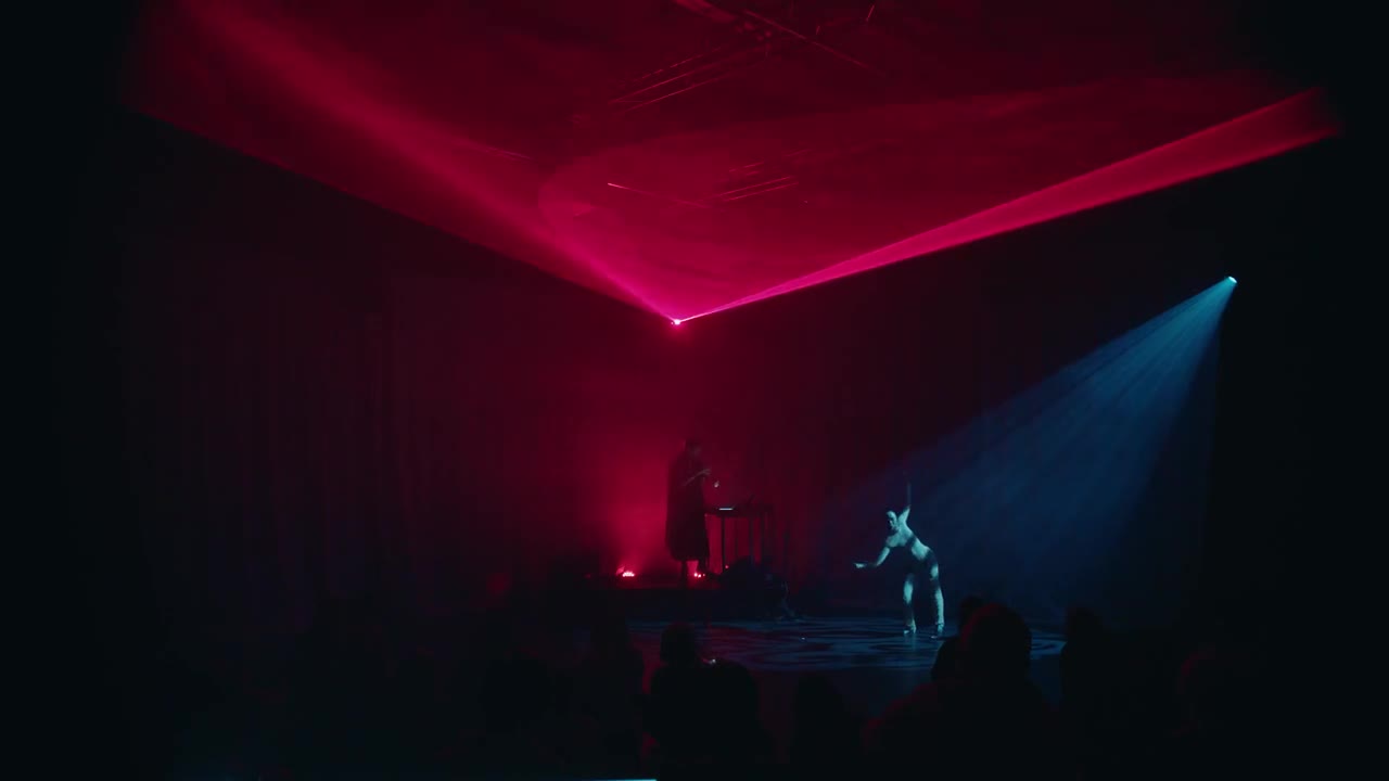 Marius Gjersø and Maiko Nishino beneath a pink laser canopy and blue stage light in Bodø
