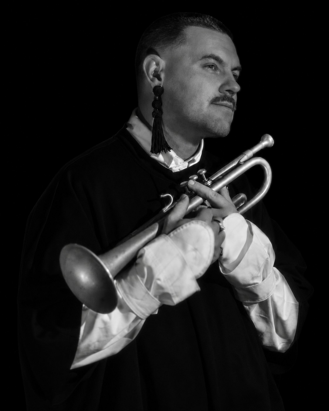 Black and white portrait of Marius Gjersø holding his trumpet, photographed by Lisa Frimanslund