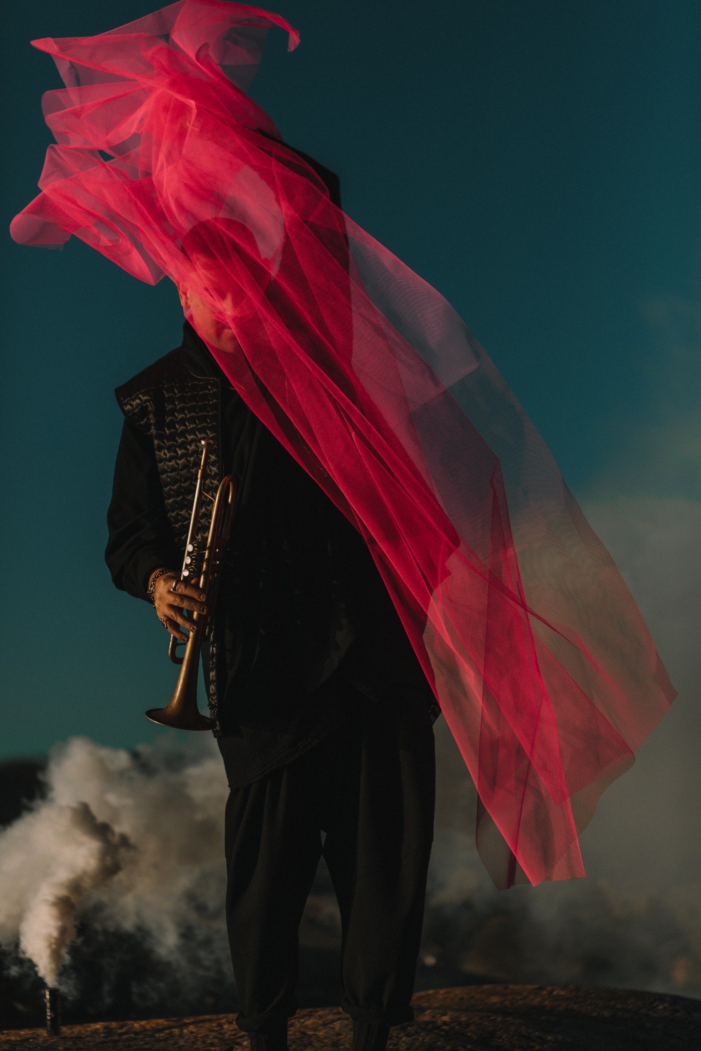 Marius Gjersø with a flowing pink veil against a dark turquoise background